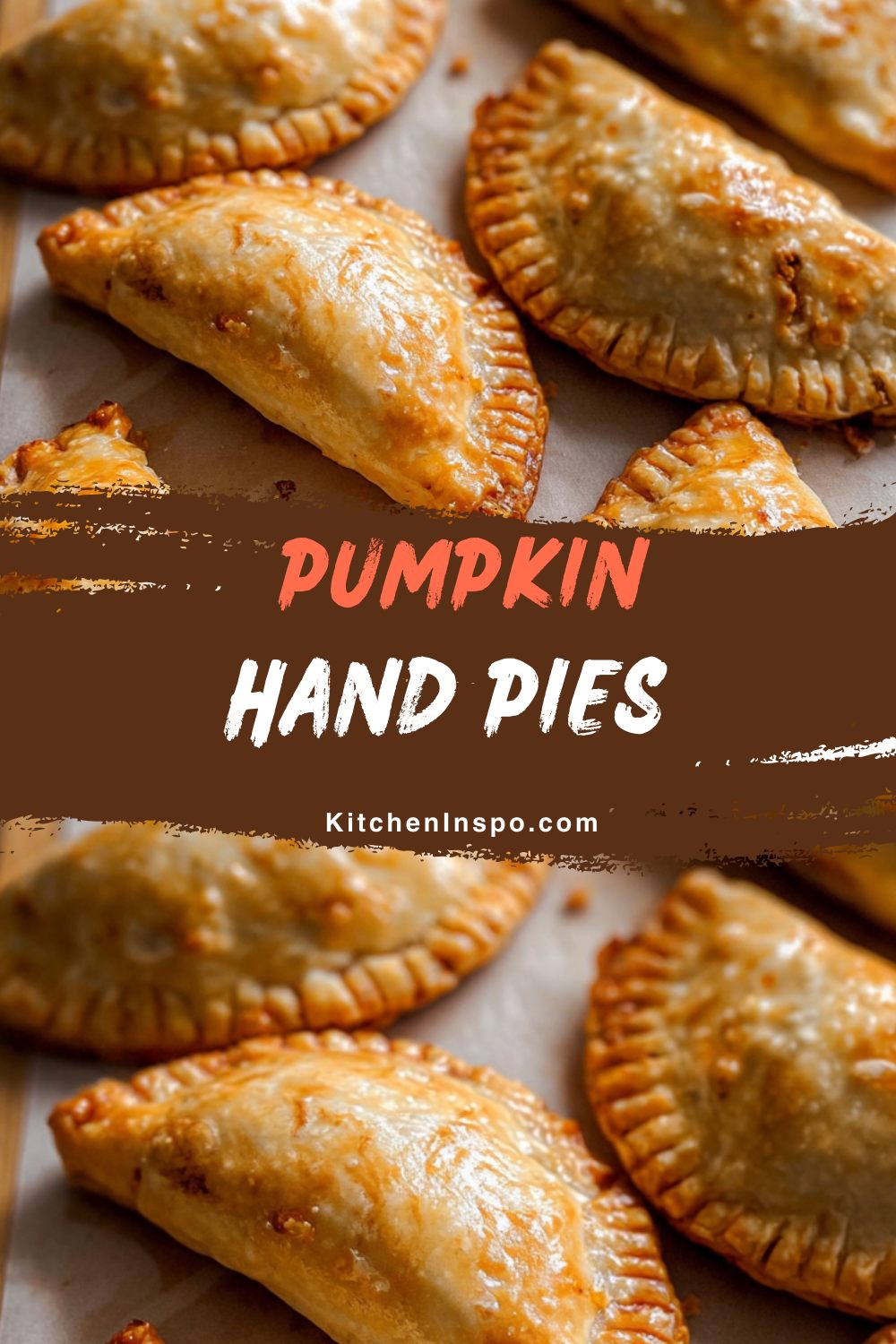 Golden, flaky hand pies filled with spiced pumpkin filling are arranged on parchment paper, making a cozy fall treat featured in delicious pumpkin recipes.