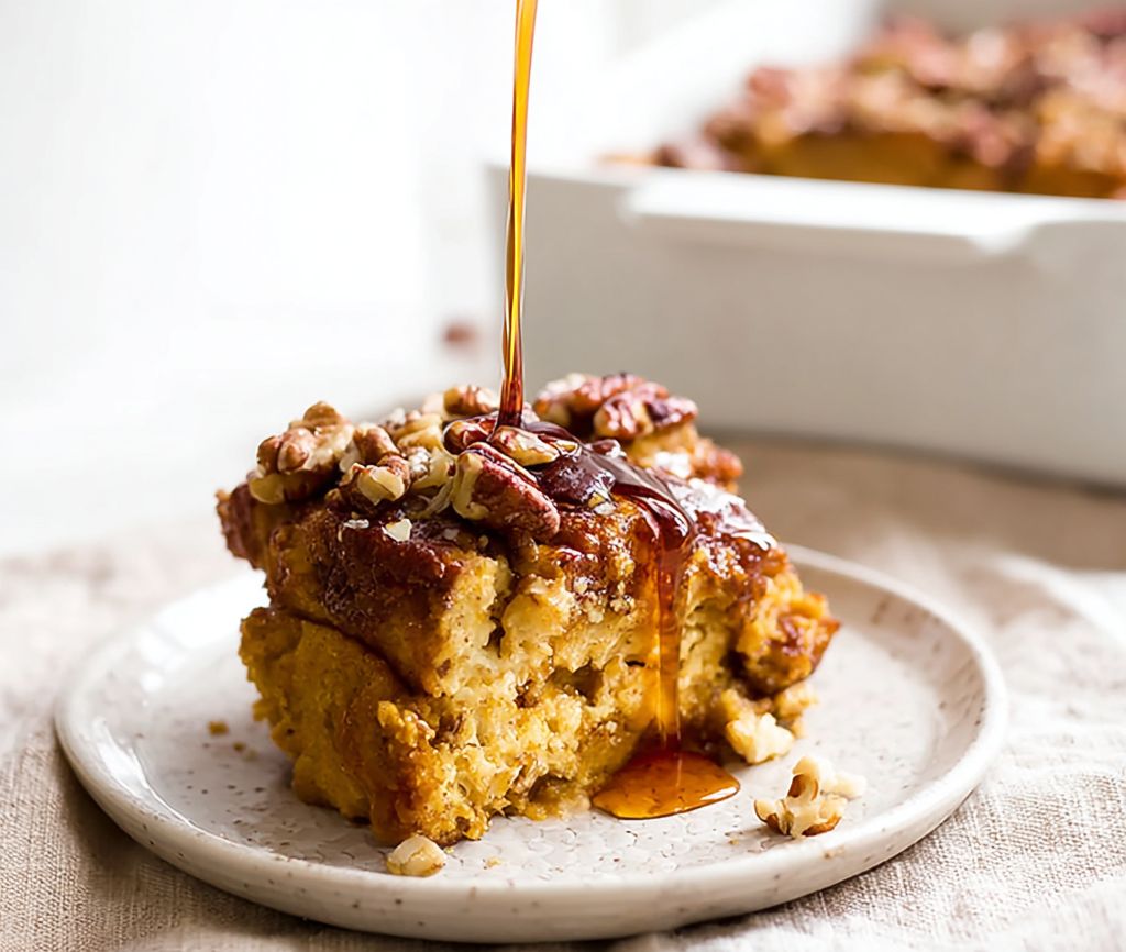Close-up of pumpkin French toast casserole baked with warm pumpkin spice, topped with syrup, served on a plate for a cozy fall breakfast.